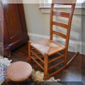 F64. Ladderback rush seat rocking chair. 